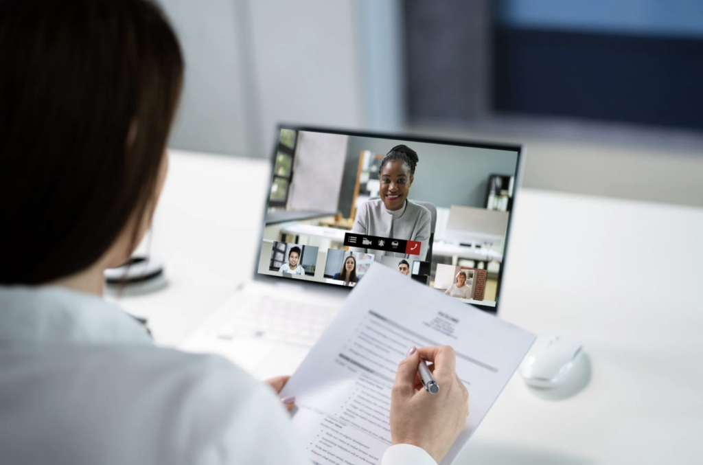 Women holding a resume virtually interviewing a women for a executive position